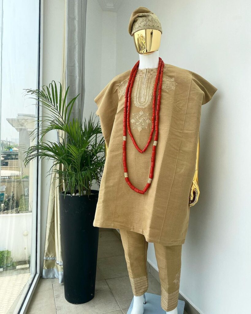 Aso-Oke Dashiki, with a floral and ancient style shaped embroidery design, hand woven Yoruba hat, an extra length red and gold coral bead.